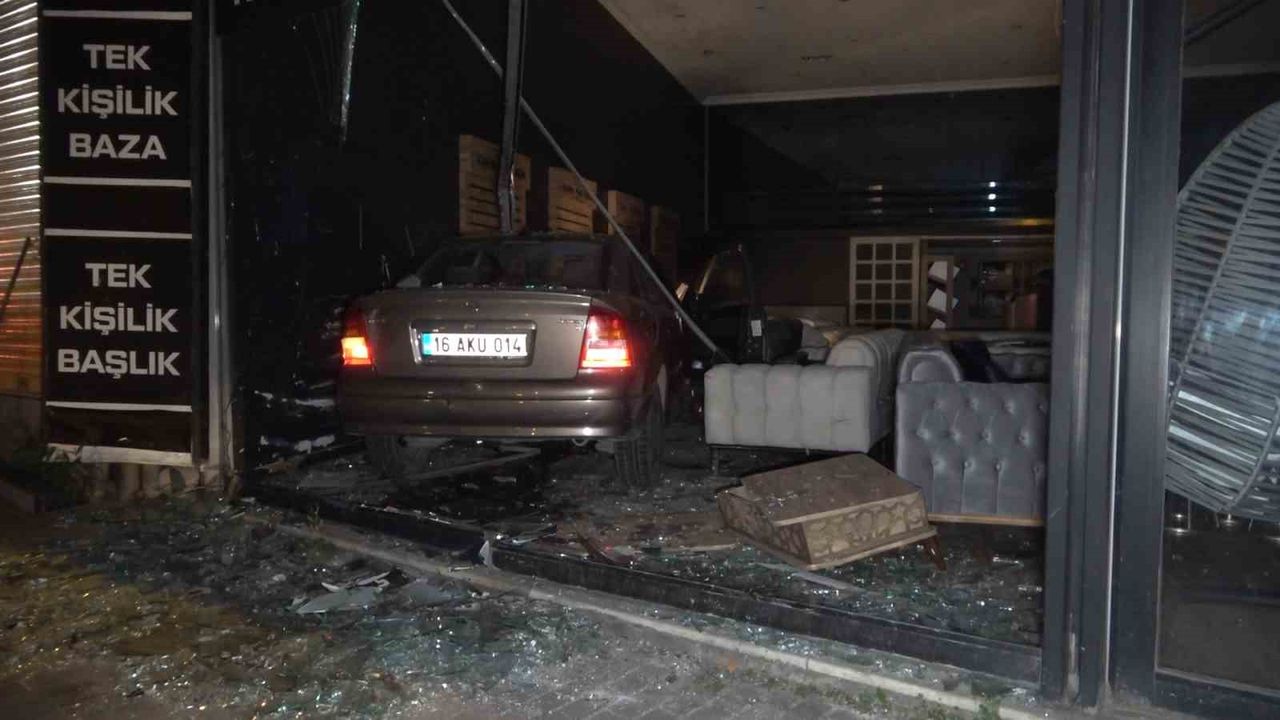 Bursa'da kontrolü kaybeden araç mobilyacıya girdi