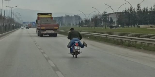 Motosikleti yüzüstü yatarak kullanan kasksız sürücü!
